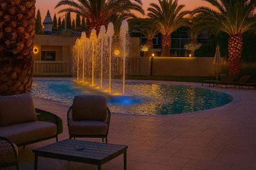 a fountain in the middle of a courtyard with palm trees at UNA HOTELS MH Matera in Matera