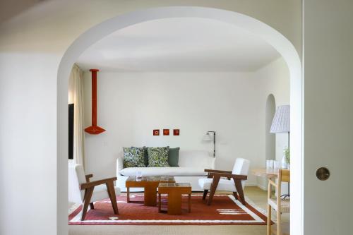 a living room with a white couch and a table at Vilalara Grand Hotel Algarve in Armação de Pêra