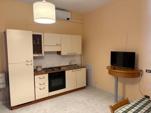 a kitchen with a white refrigerator and a tv at Residence Praetorium Maiella Park in Pretoro