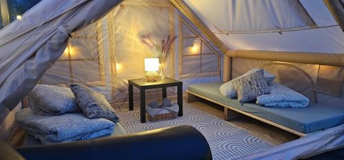a room with two beds and a table in a tent at Lighthouse Benki in Užava