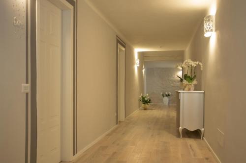 a hallway with white walls and a white door with flowers at B&B Villa Anna in Lucca