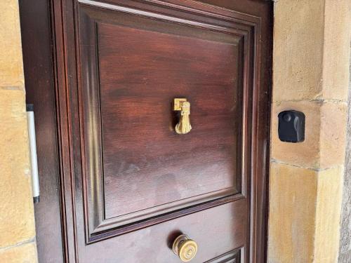a wooden door with a gold knocker on it at Chambre Lits Jumeaux in Mirepoix