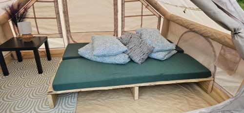 a bench in a tent with pillows on it at Lighthouse Benki in Užava
