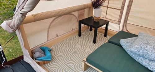 a room with a bed and a table in a tent at Lighthouse Benki in Užava
