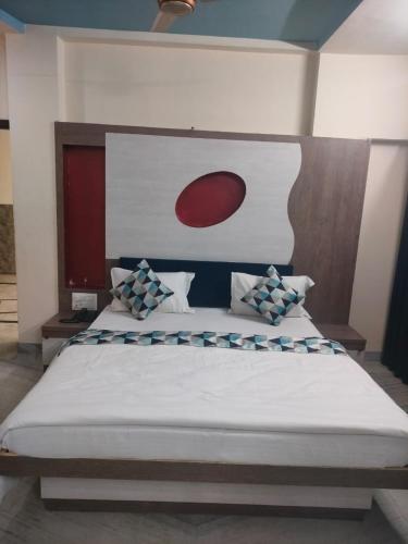a bedroom with a large bed with a red and white headboard at Shahi Palace Hotel in Nāthdwāra