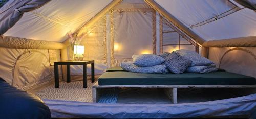 a bedroom with a bed in a tent at Lighthouse Benki in Užava