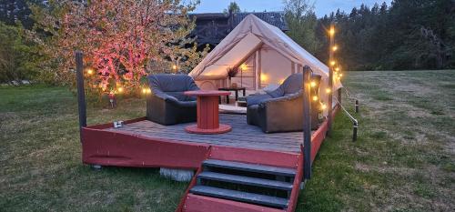 a tent with two chairs and a table and lights at Lighthouse Benki in Užava