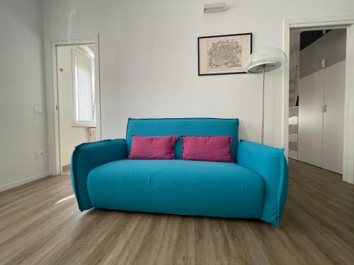 a blue couch with two pink pillows in a living room at Soria Home-A due passi da Centro e Mare in Pesaro