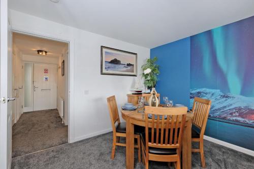 a dining room with a table and chairs and a bed at Luxury 2 Bedroom Harbour Apartment With Panoramic Ship Views in Aberdeen