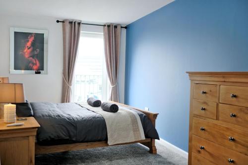 a bedroom with a bed and a dresser and a window at Luxury 2 Bedroom Harbour Apartment With Panoramic Ship Views in Aberdeen