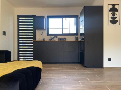 a room with a kitchen with a bed and a window at Évasion balnéo, terrasse, parking, plage - 4 pers in Arès