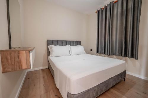 a bedroom with a large bed and a window at Edva Resort in Vlorë