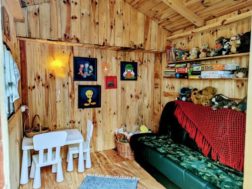 a room with a wooden wall with a bed and a table at Piecówka Wysokie Kaczki in Kaczkowo