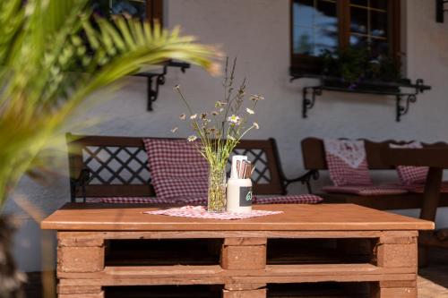 a wooden table with a vase of flowers on it at Walserkreuz Suiten in Hirschegg