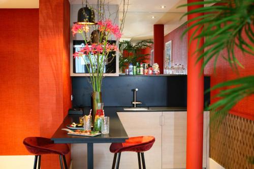 a kitchen with a table and two stools and a sink at Van der Valk Hotel Den Haag in Nootdorp