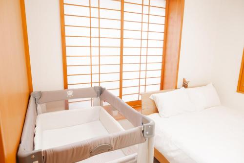 a small room with two beds and a window at Okinawa Homie Stay in Naha