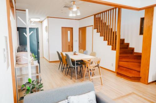 a dining room and living room with a table and chairs at Okinawa Homie Stay in Naha