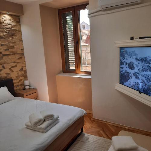 a bedroom with a bed with two towels on it at Apartman HOME Kotor in Kotor