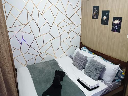 a black dog sitting on a bed in a bedroom at AA's Property in Sampong