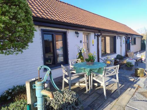 a house with a table and chairs on a patio at DHofstede vakantiewoning in Oudenaarde