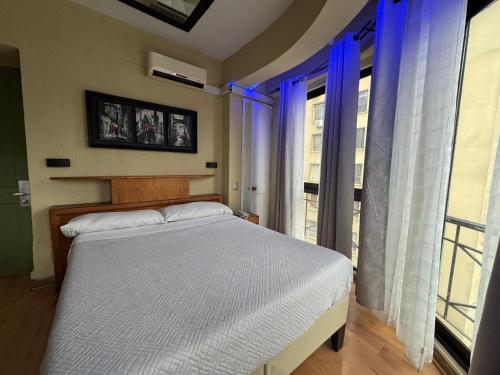 a bedroom with a bed and a large window at Intimo Hotel Miraflores in Santiago