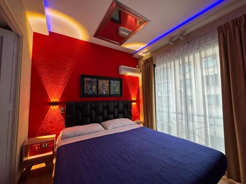a bedroom with red walls and a bed with blue lights at Intimo Hotel Miraflores in Santiago