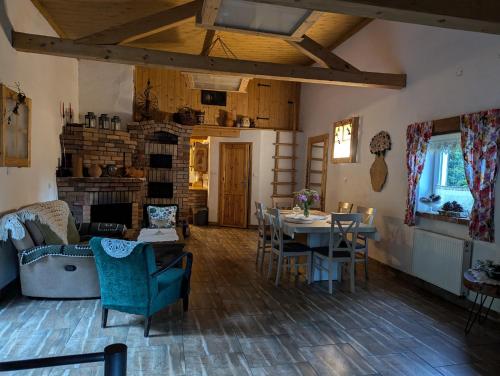 a living room with a table and chairs at Piecówka Wysokie Kaczki in Kaczkowo