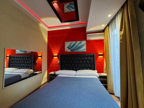 a bedroom with two beds and red walls at Intimo Hotel Miraflores in Santiago
