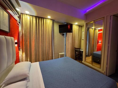 a bedroom with a bed and a tv and a window at Intimo Hotel Miraflores in Santiago