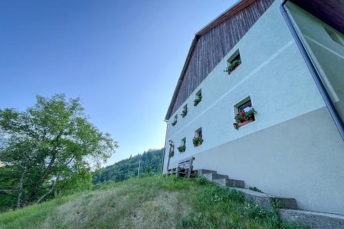 a building with potted plants on the side of it at Hikers Hut Pr Blažu in Podbrdo