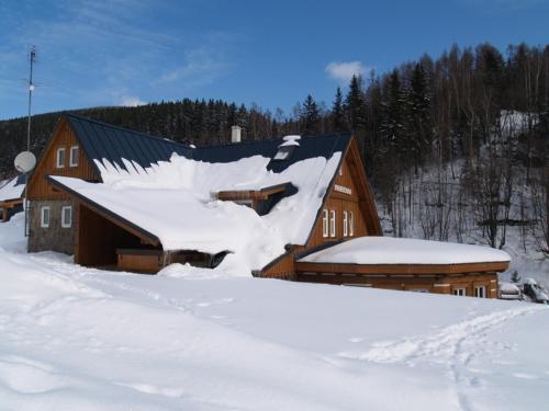 a large wooden barn covered in snow at Penzion Marienka in Pec pod Sněžkou
