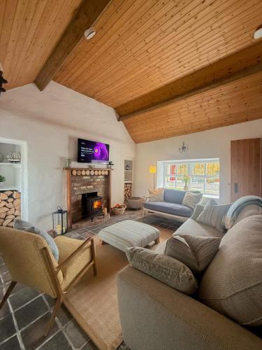 a living room with two couches and a fireplace at The Pilot's Cottage in Cornamucklagh