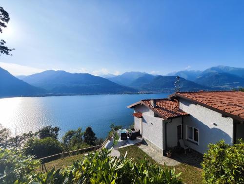 a house with a view of the water and mountains at LAGUNA BLU - Villa da sogno con idromassaggio panoramico sul Lago di Como in Colico
