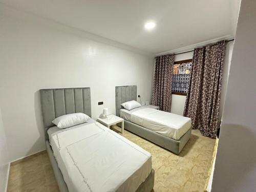 a bedroom with two beds and a window at Jb house in Chefchaouen