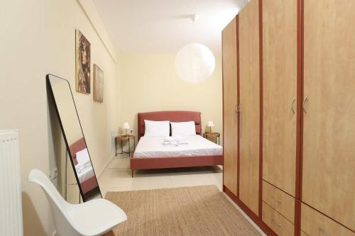 a small bedroom with a bed and a chair at The Blue Horizon House in Afitos