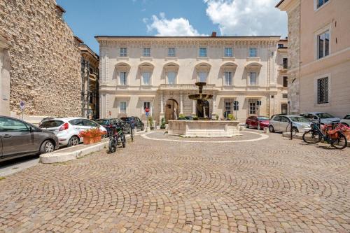 a brick street with a fountain in front of a building at PALAZZO PICALFIERI SUITE d EPOCA in LʼAquila
