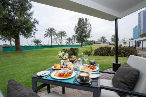 a table with plates of food on a patio at Marbella Resort in Sharjah