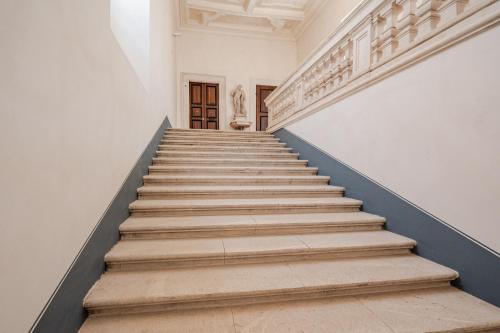 a staircase in a white building with blue trim at PALAZZO PICALFIERI SUITE d EPOCA in LʼAquila