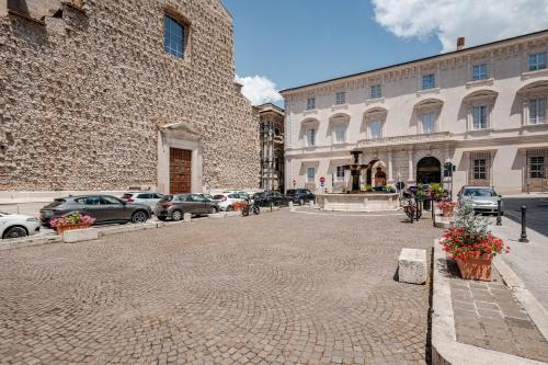 a street with cars parked in front of a building at PALAZZO PICALFIERI SUITE d EPOCA in LʼAquila
