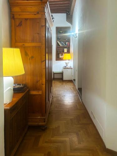 a hallway with a wooden floor and a room with two lamps at B&B La Fontanina in Siena