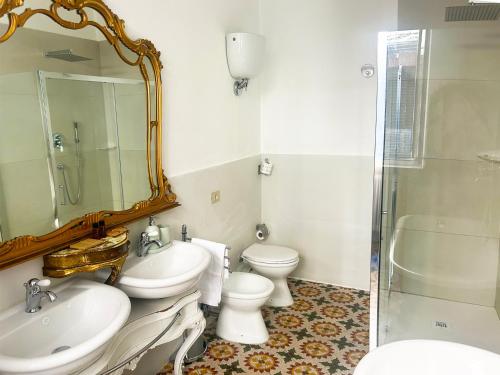 a bathroom with two toilets and a sink and a shower at B&B La Fontanina in Siena