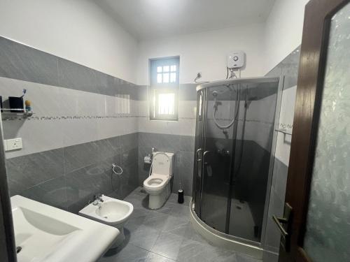 a bathroom with a toilet and a shower and a sink at Villa J&T in Katunayake