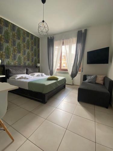 a bedroom with a bed and a couch at B&B 30 mt dal Duomo in Benevento