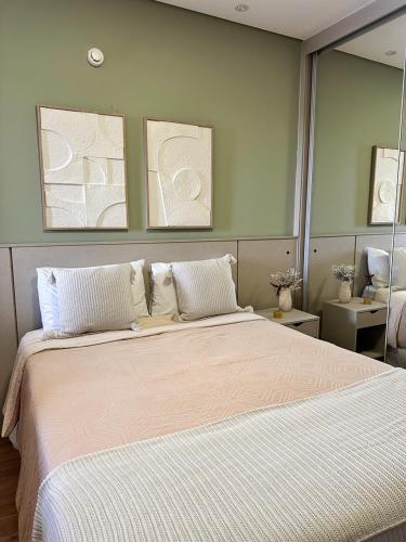 a bedroom with a large bed with white sheets at Summit Flat, ótima localização, limpeza diária, academia e piscina in São José dos Campos