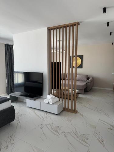 a living room with a television and a couch at Aqua Villa by the Sea in Eforie Sud