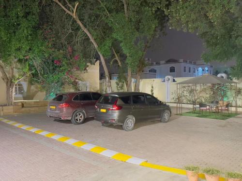 two cars parked in a parking lot at night at Star Emirates Garden Villas Salalah in Salalah