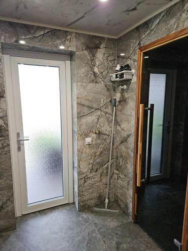 a door to a room with a window and a vacuum at Tiny Sauna House with Terrace in Veibri