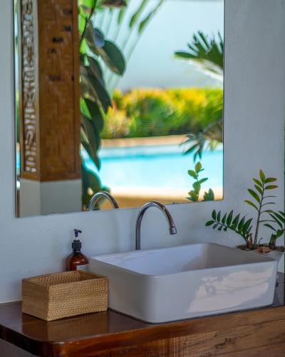 a sink in a bathroom with a mirror and a counter at Yellow Mango Resort Bohol in Panglao Island