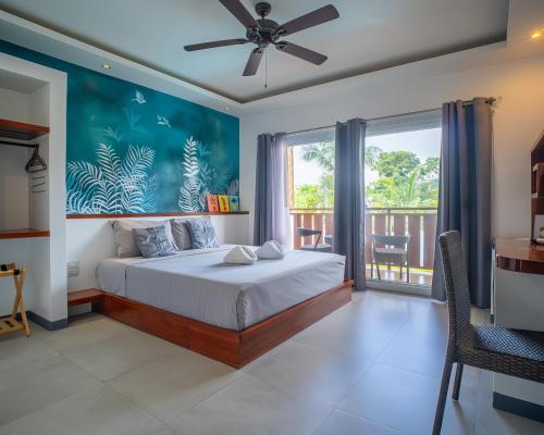 a bedroom with a bed and a balcony at Yellow Mango Resort Bohol in Panglao Island