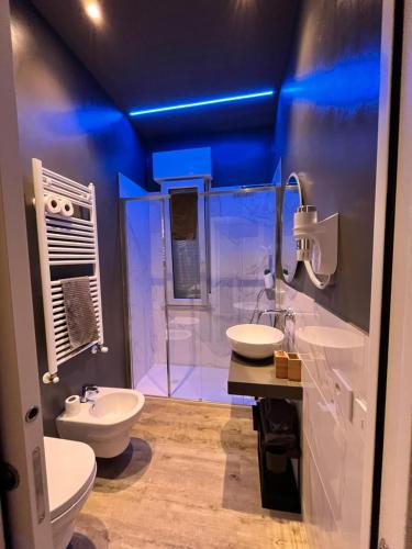 a bathroom with two sinks and a shower with blue lighting at Appartamenti Mar y Sol in Gabicce Mare